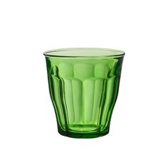 a green glass cup sitting on top of a table