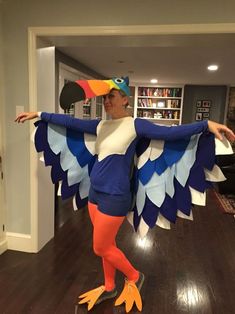 a woman is dressed up as a bird and holding her arms out to the side