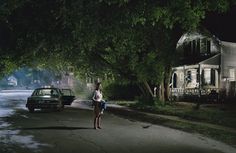 a woman standing in the middle of a street at night