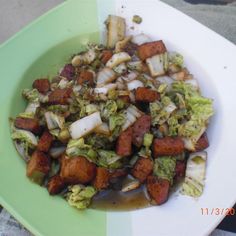 a green plate topped with lots of food on top of a white and green table