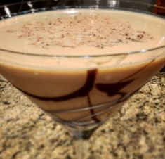 a drink in a glass sitting on top of a counter