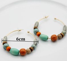 Add a unique, bohemian-style flair to your accessory collection with these hoop earrings. This pair is crafted from wooden beads that encircle a metal hoop, creating an eye-catching design that will stand out with any ensemble. Wear these earrings to bring personality, style and a southwestern flair to your look. Easy hook in, plus backing for extra protection.Measures a little over 2 inches in diameter. Free shipping, 7-18 days delivery. Wooden Beads, Bohemian Style, Hoop Earrings, Beads, Free Shipping, How To Wear, Design