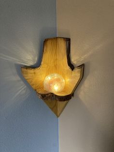 a wooden light fixture mounted to the side of a wall next to a blue wall