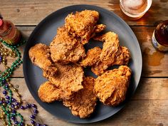 fried chicken on a plate next to beer and beads