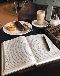 an open book sitting on top of a table next to a cup of coffee and doughnuts