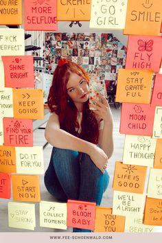 a woman sitting on the ground surrounded by post it notes