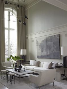 a living room filled with furniture and a large painting hanging on the wall above it