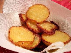 a basket filled with sliced potatoes on top of a red tablecloth covered table cloth