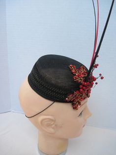 "* Designed on a black Sinamay pillbox hat form this hatinator will take you anywhere you want to go and will catch many eyes. The design includes a wide black leather braided trim complemented by handmade red sequen and bead worked Maple Leaves. To add a touch more of detail shiny red berries look good enough to eat. * The three black and red quills give dramatic height to the piece and upon ordering this is the exact fascinator you will receive. * With a hat diameter of 5.5\" it qualifies as f Vintage Black Fascinator For Party, Black High Crown Fascinator For Kentucky Derby, Black Curved Brim Costume Hat For Church, Black Costume Hat With Curved Brim For Church, Black Costume Hat For Church With Curved Brim, Black High Crown Top Hat For Races, Black High Crown Hat For Formal Occasions, Black Costume Hats For Church, Black High Crown Costume Hat For Formal Occasions