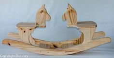 a wooden rocking horse with two horses on it's back legs and the top part missing