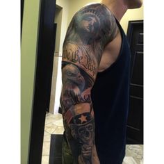 a man with a tattoo on his arm and shoulder is standing in front of a mirror