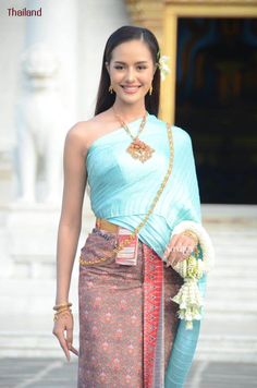 a woman in a blue and red sari is posing for the camera with her hand on her hip