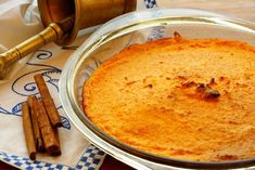 an orange cake in a pan with cinnamon sticks next to it