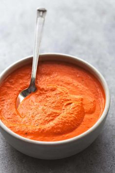 a bowl of tomato soup with a spoon in it