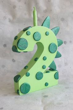 the number two is made out of wood and has green polka dot dots on it