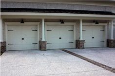 three white garages with pillars on each side and two doors at the top are open