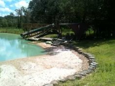 a small pool in the middle of a grassy area with stairs leading up to it