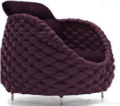 a purple chair that is sitting in the middle of a white floor and it's upholstered