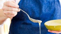 a person holding a spoon full of liquid