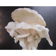 a white sculpture with shells on top of it