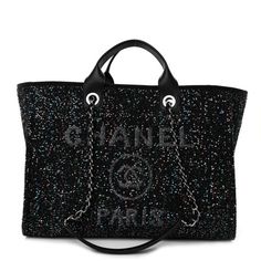 This is an authentic CHANEL Calfskin Sequin Medium Deauville Tote in Black. This stylish tote is crafted of sequined canvas in black, with a glittered Chanel Rue Cambon Paris logo. It features rolled leather top handles andfabric threadedsilver chain shoulder straps. The top is open toa black fabric interior with zipper and patch pockets. Chanel Rue Cambon, Chanel Tote Bag, Paris Logo, Chanel Tote, Chanel Caviar, Shopper Tote, Travel Tote, Shopping Tote, Leather Top