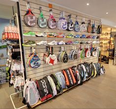 there are many tennis rackets on display in the store and one is for sale