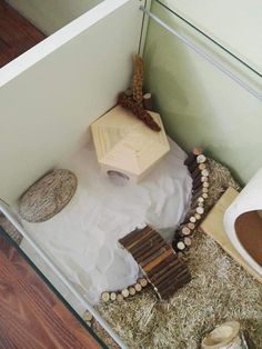 a small wooden structure sitting on top of a pile of hay next to a toilet