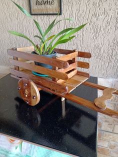 a wooden cart with plants in it sitting on a table