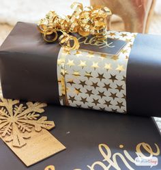 a gift wrapped in black and gold paper