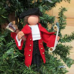 a christmas tree ornament with a red coat and black hat holding a knife