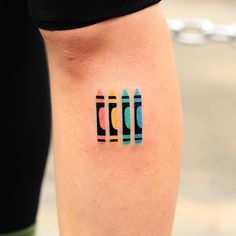 a person with a tattoo on their leg that has three pencils painted on it