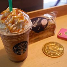 a starbucks drink with caramel and macaroni cheese on it next to a gold coin