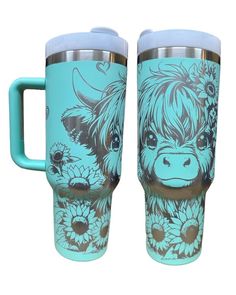 two travel mugs one with a cow and flowers painted on the side, both have handles