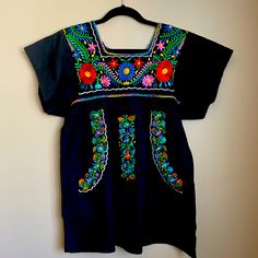 Mexican Dress, With Multicolored Beautiful Embroidery. Cotton Dress That Can Be Worn As A Dress Or Top, Or Cover Up. Measurements Laid Flat: 19” Bust, 21” From Underarm To Underarm, 29 1/2 Length From Shoulders L, And 5” Slits On Sides. Never Worn, Bought In Mexico, No Tags. Black Cotton Embroidered Dress With Floral Embroidery, Black Cotton Dress With Floral Embroidery, Black Cotton Folk Embroidered Dress, Black Cotton Folk Dress, Black Folk Style Cotton Dress, Black Folk Dress With Floral Embroidery, Fitted Cotton Embroidered Black Dress, Black Short Sleeve Embroidered Dress With Floral Details, Black Cotton Embroidered Short Sleeve Dress