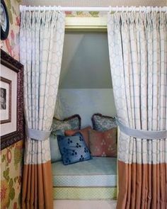 a bed sitting under a window next to a wall with pictures hanging on the walls