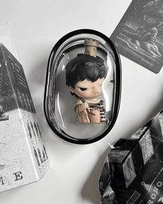 a small figurine sitting on top of a table next to some books and other items