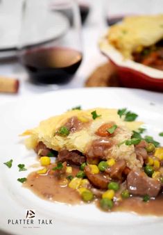 a white plate topped with meat and veggies covered in gravy