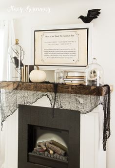 a fireplace decorated for halloween with black and white decor