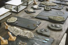 many different types of jewelry are displayed on a table with mirrors and other items in the background