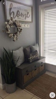 a bench with some pillows and a wreath on it next to a window sill