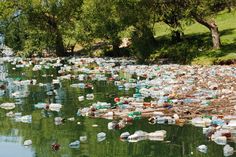 a river filled with lots of plastic bottles floating on top of it's sides