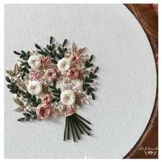 a bouquet of flowers is embroidered onto a white piece of fabric