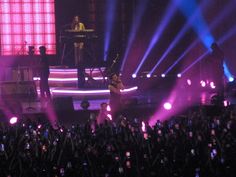 a group of people standing on top of a stage in front of a large crowd