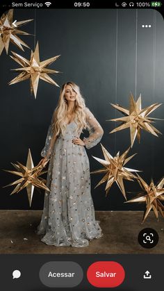 a woman standing in front of gold stars