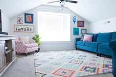 a living room with a blue couch and colorful rug