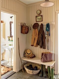 there is a coat rack with hats and boots on the bench in this entryway