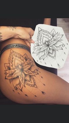 a woman's thigh with tattoos on it and a flower tattoo design on the side