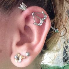 a close up of a person's ear with three different piercings on it