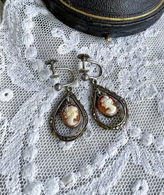 Featuring a beautiful pair of demure antique Victorian stamped 800 silver screw back dangle  earrings adorned with luminous genuine carved Conch Shell Cameos set in open back pronged settings.  Earrings measure approximately 1.5  inches long at 5. grams respectively.  Both pieces are in excellent antique condition with functional backs, a beautiful patina with all components intact and accounted for.  Stamped 800 on the reverse of both earrings these a just beautiful! An investment worth wearing Vintage Sterling Silver Clip-on Earrings, Antique Silver Vintage Dangle Jewelry, Antique Dangle Earrings, Vintage Antique Silver Dangle Jewelry, Vintage Antique Silver Dangle Earrings, Nickel-free Antique Silver Jewelry, Vintage Pierced Drop Earrings, Antique Silver Clip-on Earrings For Wedding, Vintage Silver Teardrop Clip-on Earrings