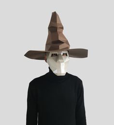 a man wearing a paper mask with a hat on his head and black shirt underneath